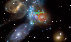 In this image, the blue, green and red colours in the central part indicate speeds derived from the WEAVE spectra and are superimposed on an image of Stephan's Quintet composed of starlight (from the CFHT telescope) and X-ray emission from hot gas (bluish vertical diffuse band, from the Chandra X-ray Observatory). The speeds obtained by WEAVE indicate that the left-centred galaxy (NGC 7318b, painted blue) is entering the group from behind at about 800 km/s (almost 3 000 000 km/h). This high-speed collision 